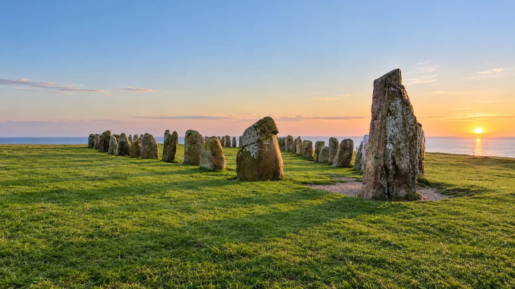 Ale's Stones, the stone ship at Kåseberga on the Österlen coast, at sunset over the Baltic.