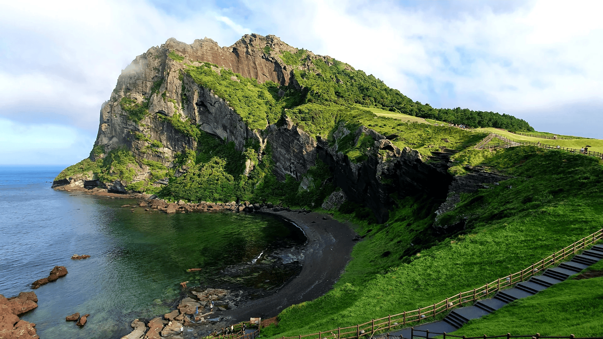 Private coastal estate on Jeju Island, volcanic coast and southern sea beyond.