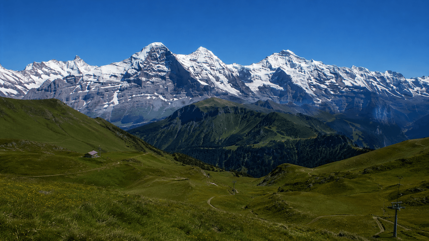 A chalet on the south-facing terrace of Verbier, the Grand Combin massif beyond, Val de Bagnes, Valais, Switzerland.
